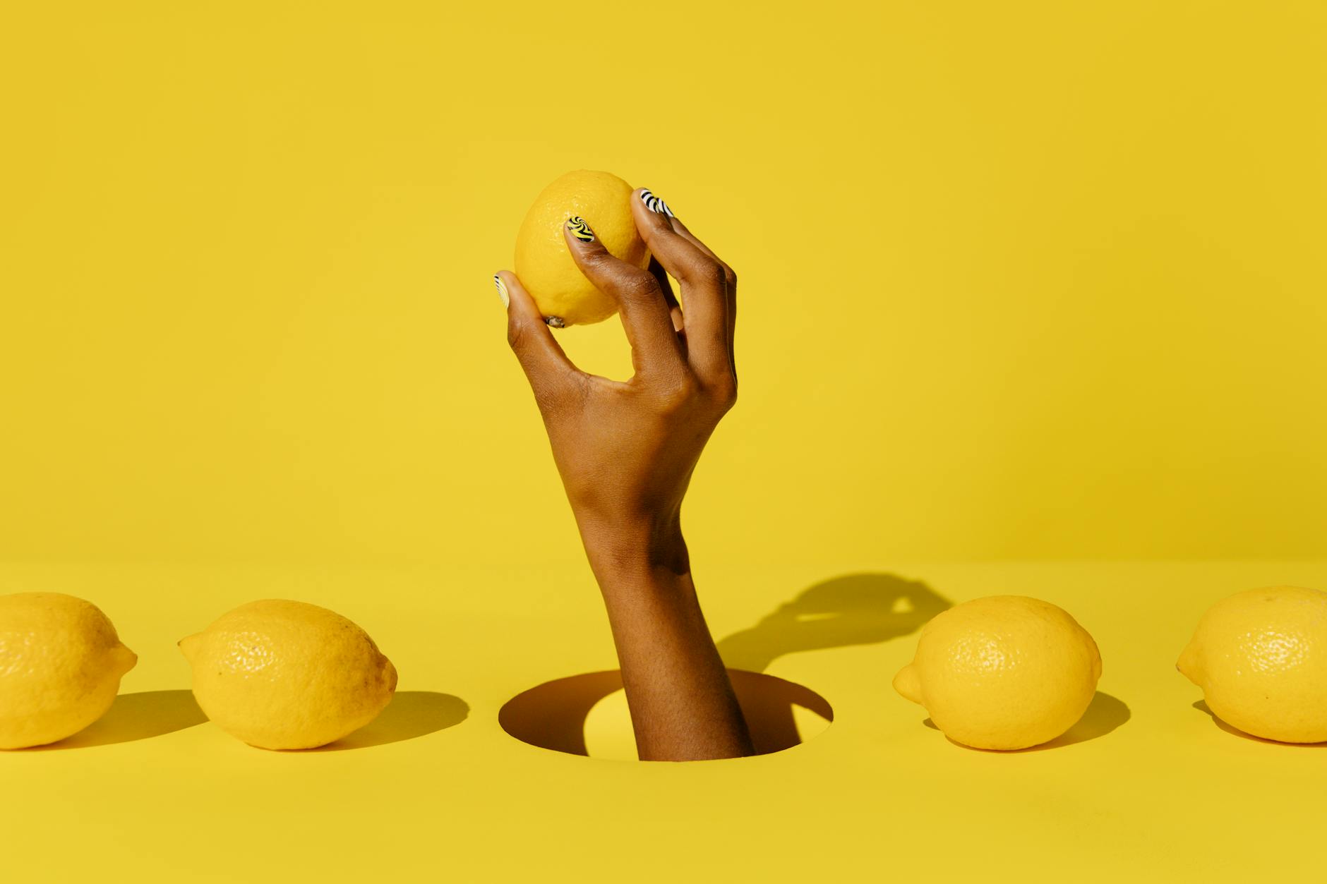 A lemon held against a vivid yellow background, symbolizing fresh sensation and renewal