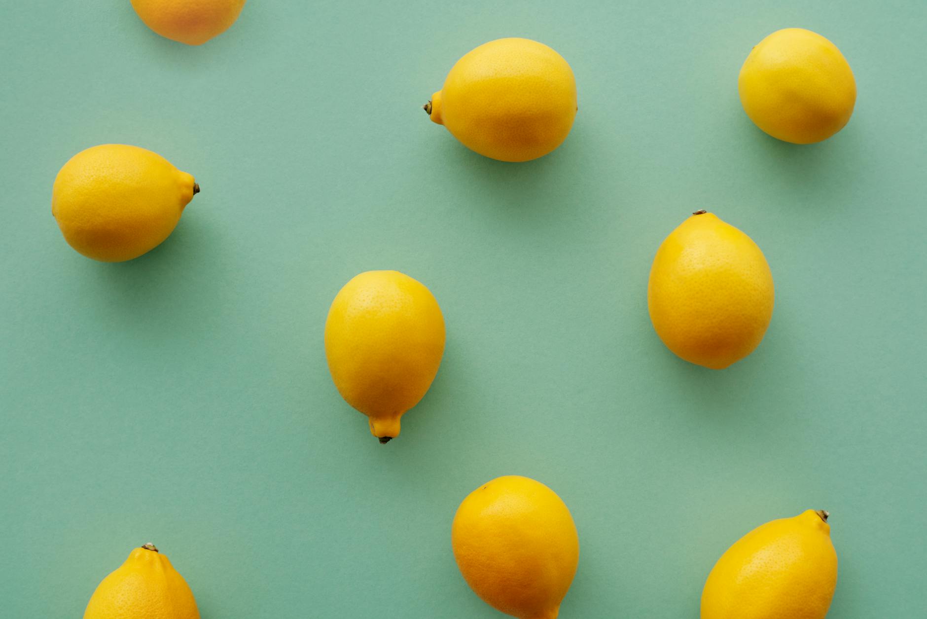 Yellow silicone vibrator surrounded by fresh fruit on a yellow background