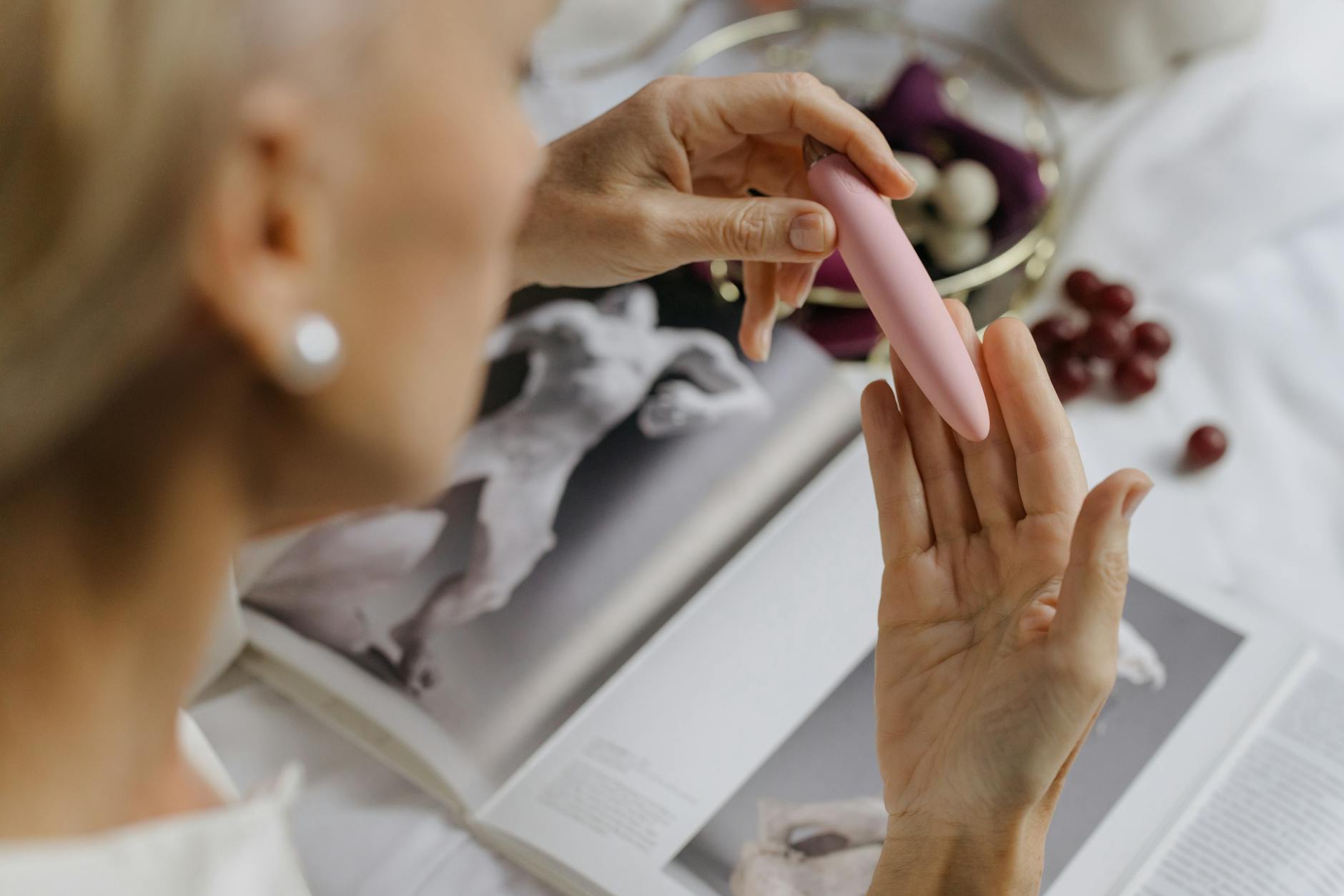 Close-up of a woman holding a pink vibrator in her hand, emphasizing intimate self-exploration and personal pleasure